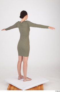 Vanessa Angel dressed green long sleeve dress standing t poses…